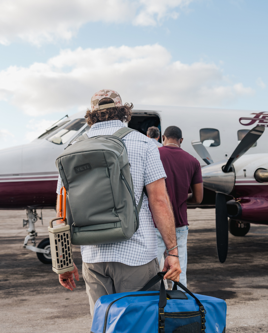A lifestyle photo of a guy with Ranger speaker attached to a backpack with our Carabiner product