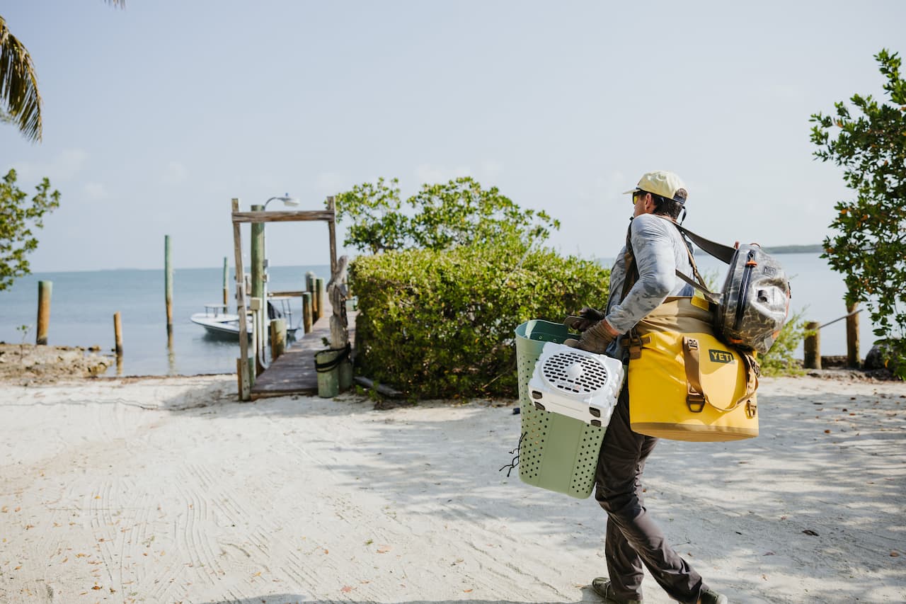 A lifestyle photo of a guy with back packs and a Original Gen 3 white speaker. #speaker-color_white